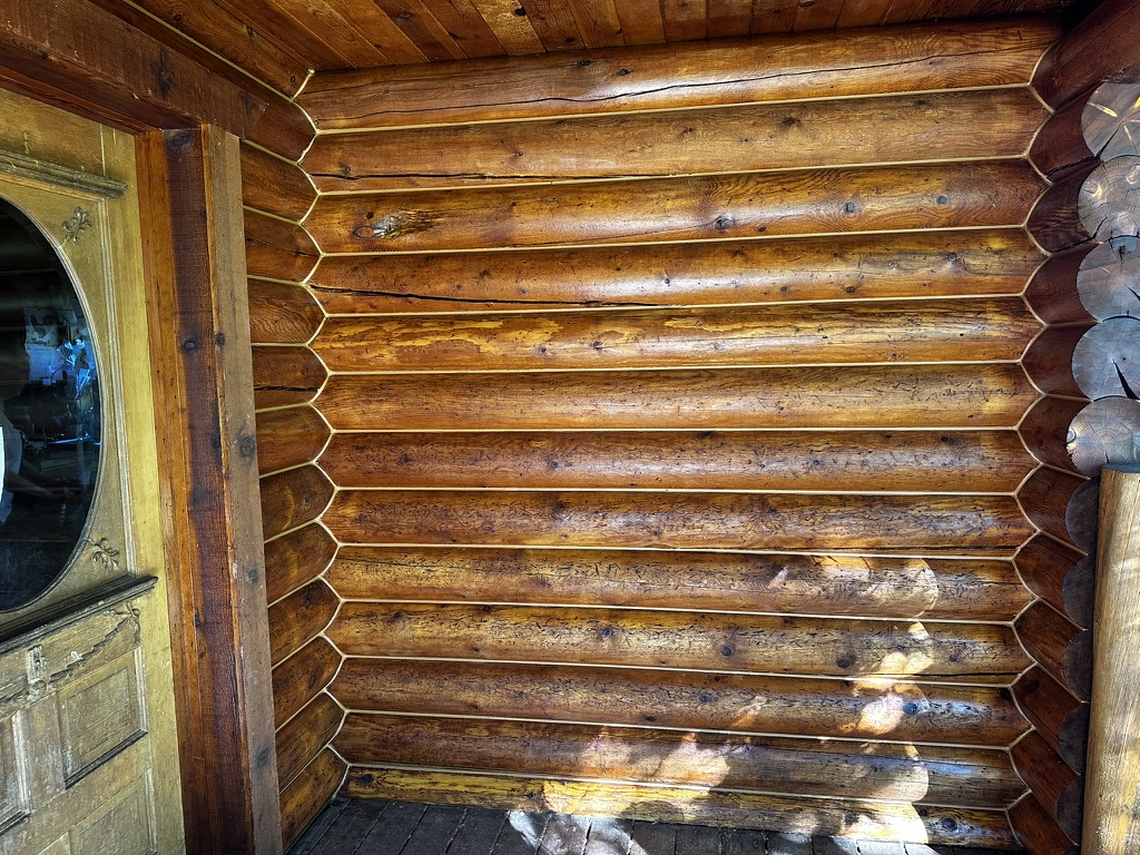 Stained log home interior wall with warm finish