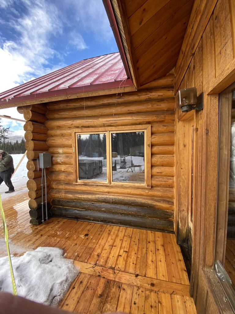 Log home corner and deck in winter conditions